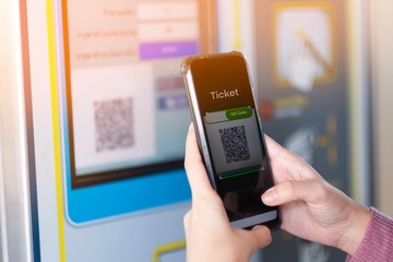 A girl scan QR code for buying the train ticket - obrazy, fototapety, plakaty