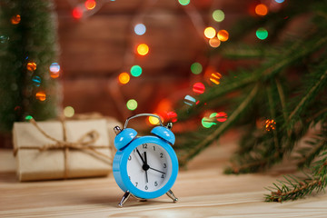 concept, New Year is coming, the alarm clock on the table among the Christmas tree and decorations