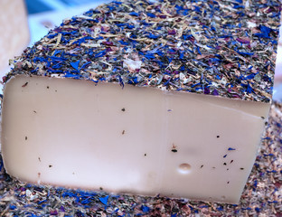 artisanal cheese with the crust covered by the flowers of the mountain pasture from which the milk comes