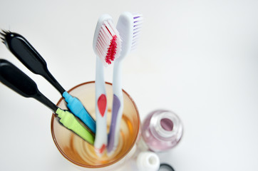 multi-colored toothbrushes in a glass on a light background top view, selective focus, mouthwash