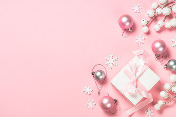 Christmas present box and decorations on pink background.