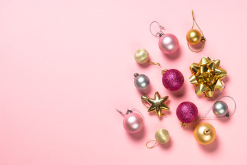 Christmas flat lay background with pink and white decorations on pink.