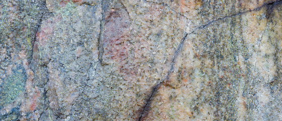 Granite texture. Granite rocks with porous surface. Background from solid stone. Pattern with natural material. Widescreen