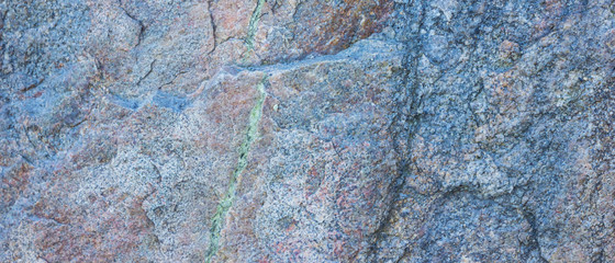 Granite texture. Granite rocks with porous surface. Background from solid stone. Pattern with natural material. Widescreen
