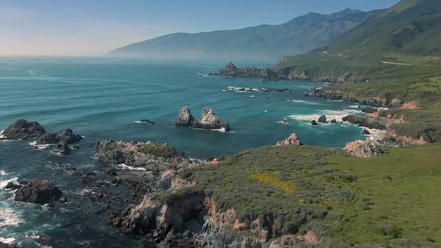 Aerial flying over rocky Shoreline Of Waves Crashing On Rocks. Big Sur, California