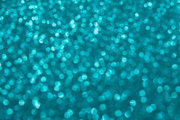 Turquoise festive background shining sparkles bokeh, turquoise gold. Glitter texture, layout for design. Modern magic background. Holidays concept.