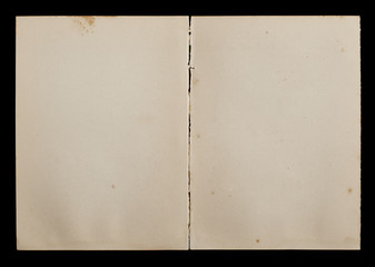 Antique book unfolded showing textured pages isolated on black background.