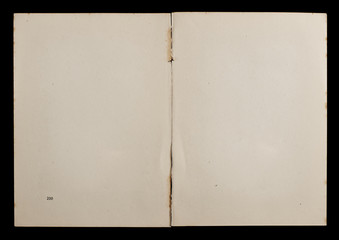 Antique book unfolded showing textured pages isolated on black background.