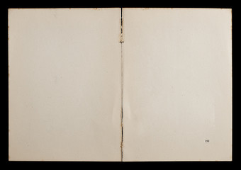 Antique book unfolded showing textured pages isolated on black background.