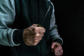 A man with a screwdriver in his hand. Criminal wielding a screwdriver.
