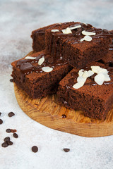 Delicious brownie chocolate cakes poured with warm chocolate and decorated with almond petals. Vertical orientation
