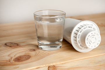 filter for cleaning tap water for drinking and a glass of filtered clean water