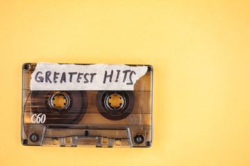 vintage old film music cassette on a yellow background with the inscription greatest hits,...