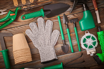 Gardening tools on wooden background flat lay top view
