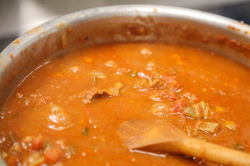 Pot with stew cooking with a spoon