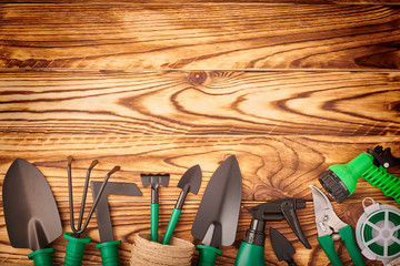 Gardening tools on wooden background flat lay top view