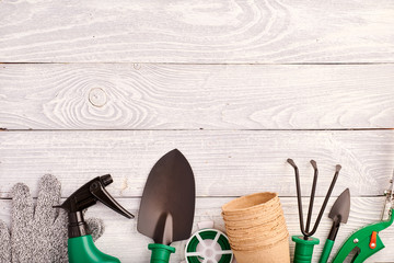 Gardening tools on wooden background flat lay top view