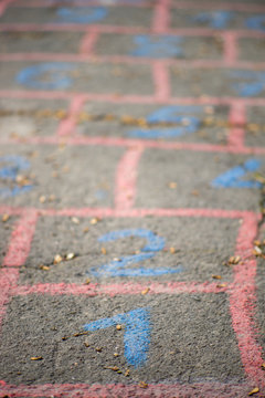 Children's hopscotch game painted on an old asphalt road.