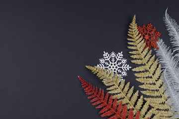 Christmas or winter composition. white and red snowflakes, multi colored tree branches on black background.