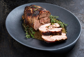 Gegrillter marinierter griechischer Lammbraten mit Kräuter in Bratensauce als closeup auf einem Modern Design Teller