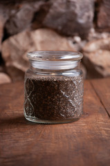 Chia jar on the rustic table with stone background. Vertical with copyspace.