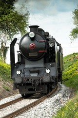 A steam passenger train arrives