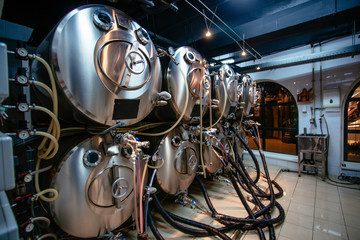 Beer kegs connected with pipes for beer serving at the bar in pub