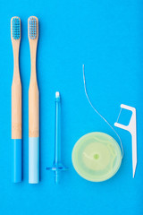 Toothbrushes and oral care tools over blue background top view copy space flat lay. Tooth care, dental hygiene and health concept.