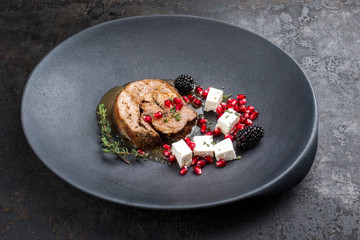 Gravy Greek lamb roast with feta cheese and fruits as minimalistic gourmet meal as closeup in a modern design plate with copy space