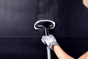 Fototapeta na wymiar Woman steaming black tissue. Hausework and lifestyle concept