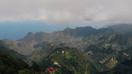 Strong wind high in the mountains, aerial view of the valley and small villages in the mountain range