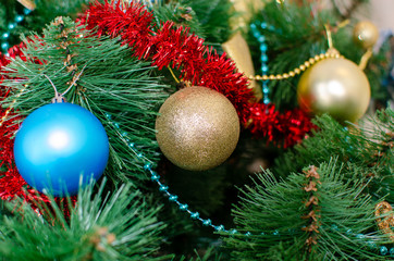 Christmas toys decorated with decorations and ribbons on a Christmas tree. New Year tree concept. Preparing for the winter holidays.