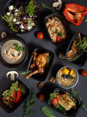 Culinary dishes made from natural products in a plastic bowl on the background with ingredients for cooking. Healthy food delivery concept. Top view.