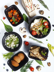 Culinary dishes made from natural products in a plastic bowl on the background with ingredients for cooking. Healthy food delivery concept. Top view.