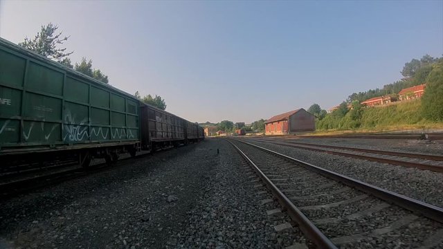 FPV drone shot flying low close to the railways on a train station
