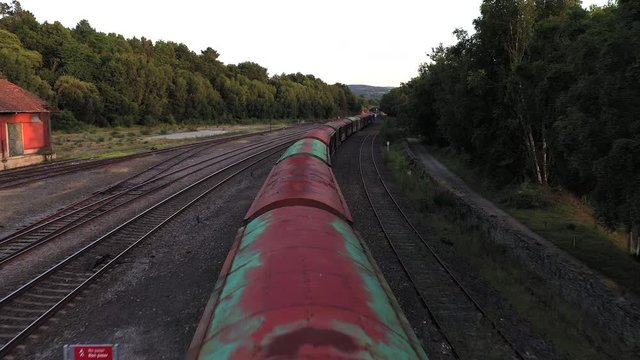 Aerial flying over a rusty unused train in Lalin station and revealing a beautiful scene