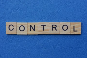 Fototapeta premium word control made from wooden letters lies on a blue background