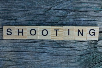 word shooting made from wooden letters lies on a gray background