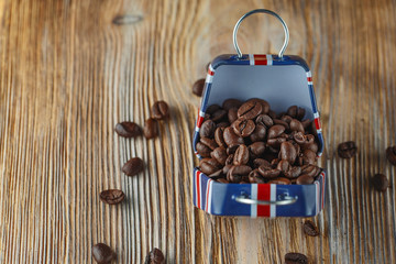 Coffee beans in the small case with britain flag pattern on wooden background.