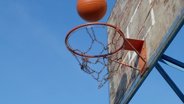 Close view of a basketball hoop, player dunks into hoop, 4k slow motion