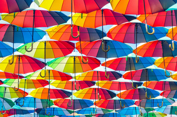 Fototapeta premium Hanging multicolored colorful umbrellas adorn the alley, street decoration