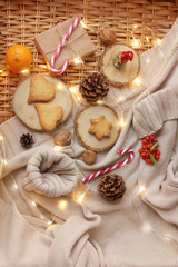 box with a gift in kraft paper, tied with twine, cones, gingerbread cookies, garland lights, caramel Christmas sticks, christmas and new year concept, copy space