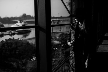 beautiful woman in a black hat with red lips in sunglasses. amid a panoramic window. business woman