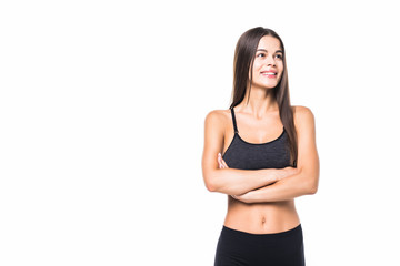 Fototapeta na wymiar Happy fitness woman standing with arms folded over white background and looking at camera