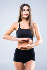 Beautiful portrait woman hand gesture heart shape on belly, girl wearing sport clothing with exercising isolated on white background.