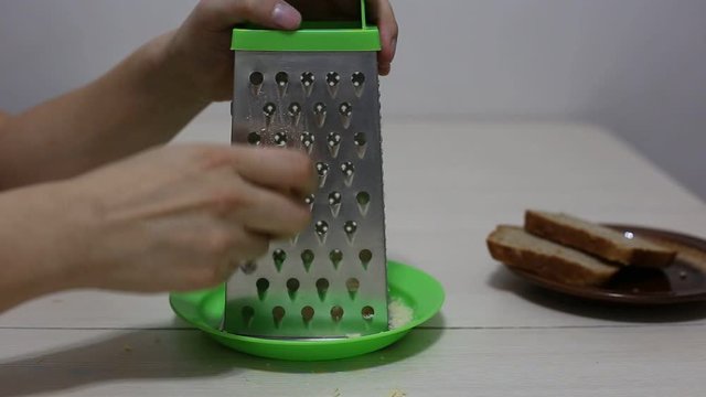 Hands grating cheese. Close-up footage.