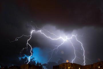 Bright lightning in the black sky over the city