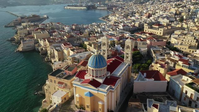 Aerial drone video of picturesque district built by the sea of Vaporia in main town of Syros or Siros island Ermoupolis and famous church of Agios Nikolaos, Cyclades, Greece