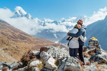 Papier Peint photo autocollant Ama Dablam Embracing couple having a rest on Everest Base Camp trekking route near Dughla 4620m. Backpackers left Backpacks, embracing and enjoying valley view with Ama Dablam 6812m peak