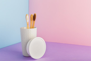 Bamboo toothbrushes and dentifrice tooth powder on color pink background. Biodegradable natural bamboo toothbrush, dentifrice tooth powder. Eco friendly, Zero waste, Dental care Plastic free concept.